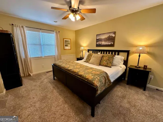 a large bed sitting in a bedroom next to a window