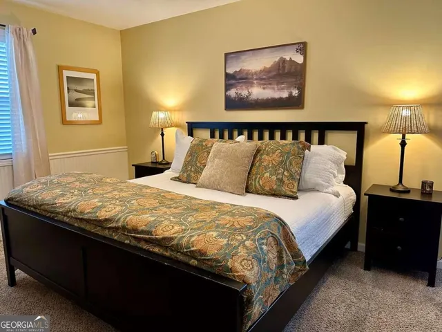 a bedroom with a bed and a painting on the wall