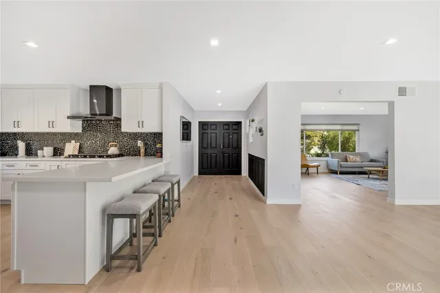 a view of a kitchen with kitchen island white cabinets and stainless steel appliances