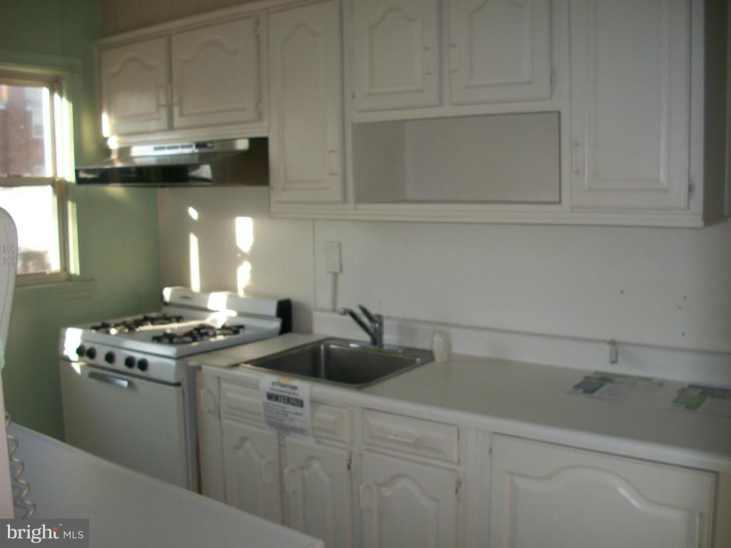 1936 Penhall Road Baltimore, MD 21222 - Photo 11 of 14 a kitchen with stainless steel appliances granite countertop a sink a stove and cabinets