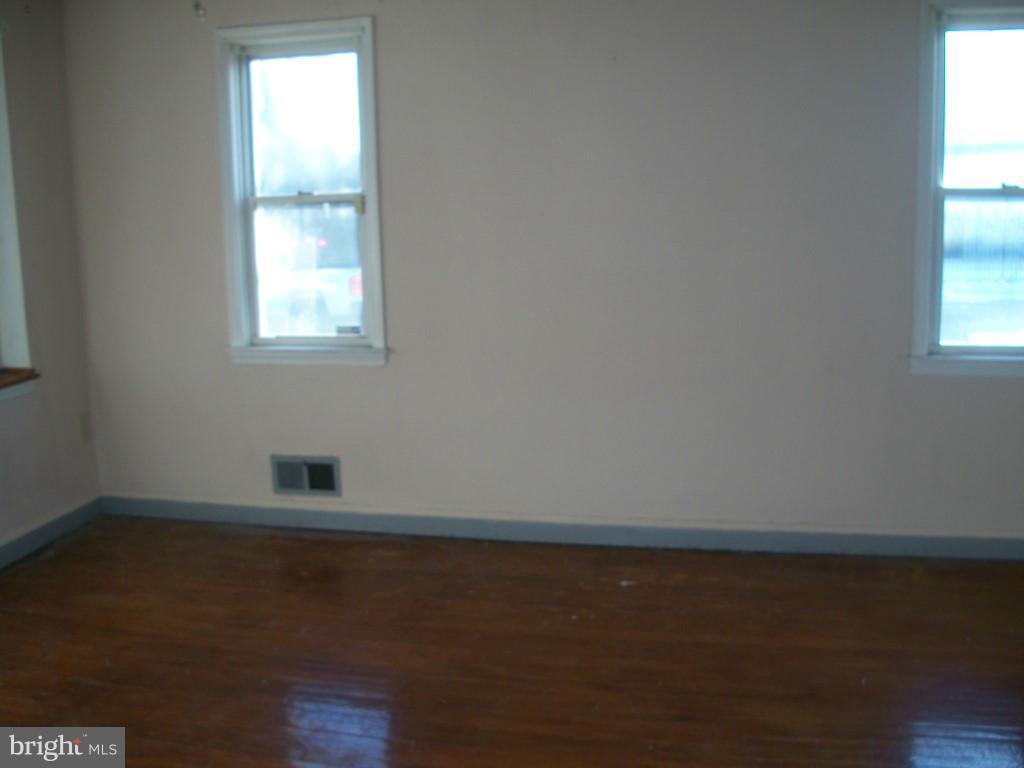 1936 Penhall Road Baltimore, MD 21222 - Photo 12 of 14 a view of an empty room with wooden floor and a window