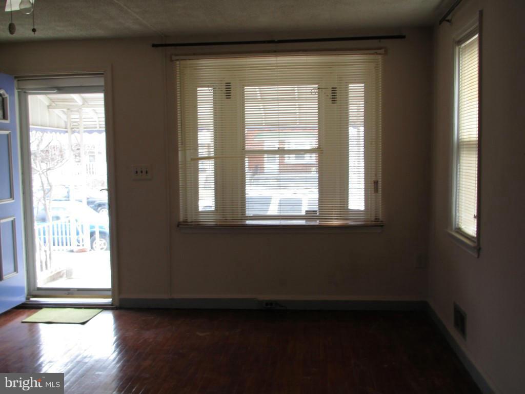 1936 Penhall Road Baltimore, MD 21222 - Photo 3 of 14 a view of an empty room with wooden floor and a window