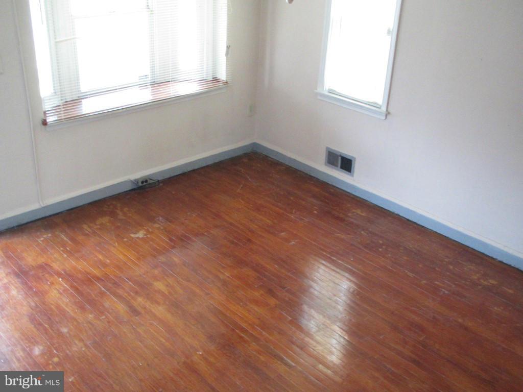 1936 Penhall Road Baltimore, MD 21222 - Photo 5 of 14 an empty room with wooden floor and windows