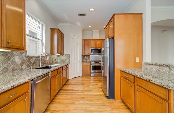 a large kitchen with granite countertop a large counter top stainless steel appliances and cabinets