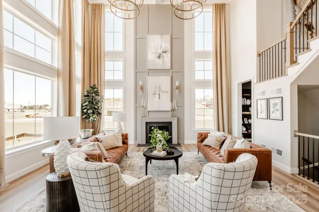 a living room with furniture fireplace and large windows
