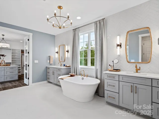 a bathroom with a double vanity sink mirror and bathtub
