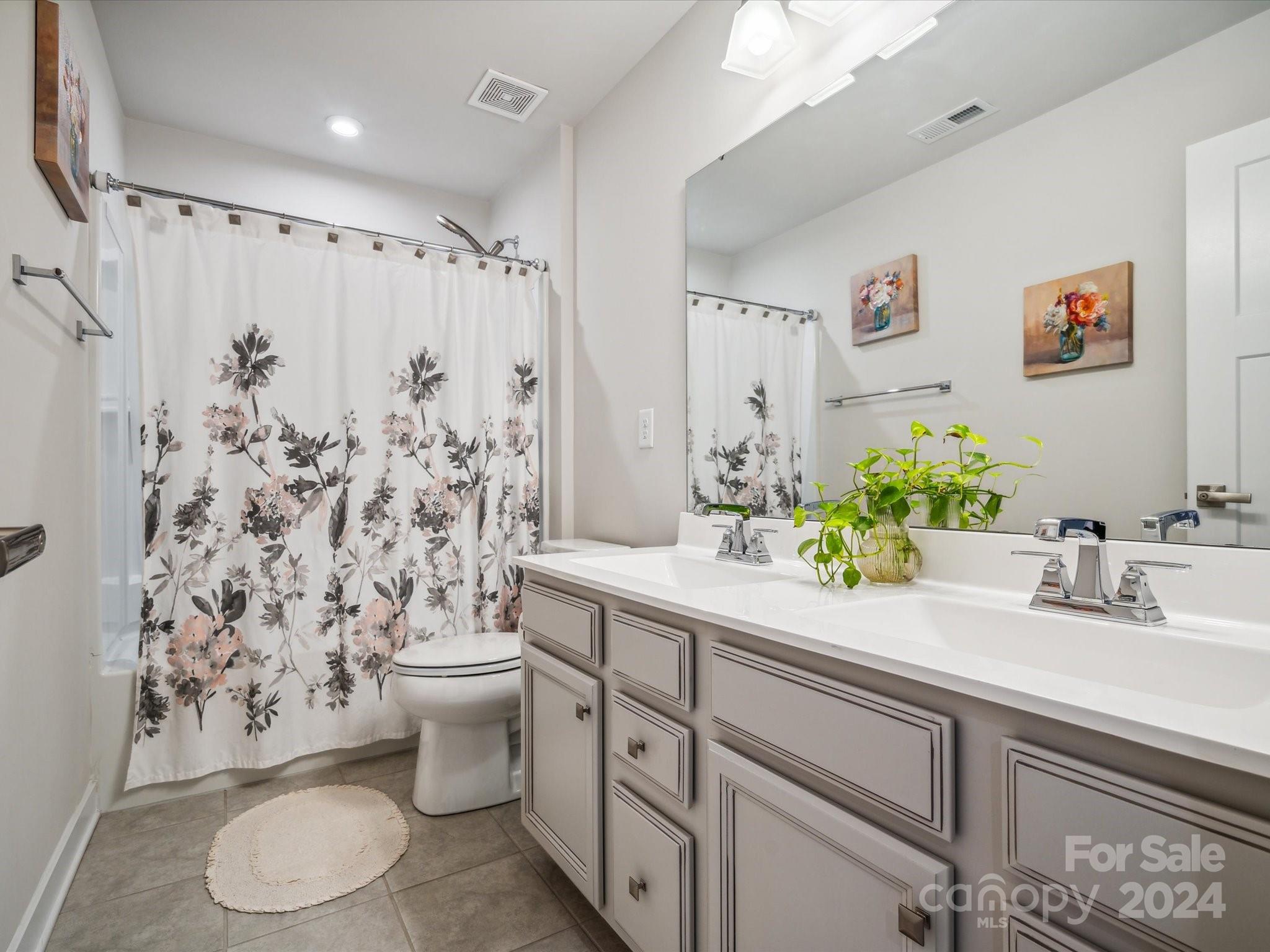 7114 Messina Road Indian Land, SC 29707 - Photo 29 of 40 a bathroom with a granite countertop sink a toilet and a shower curtain