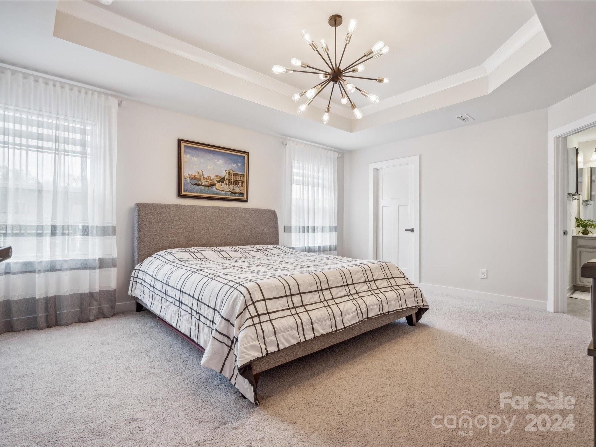 7114 Messina Road Indian Land, SC 29707 - Photo 30 of 40 a bedroom with a large bed and a chandelier