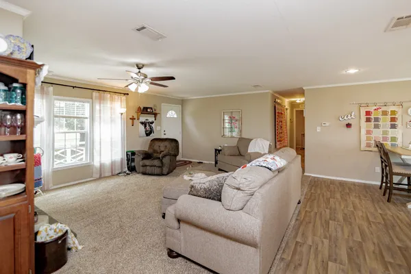 a living room with furniture a dining table and chairs with wooden floor