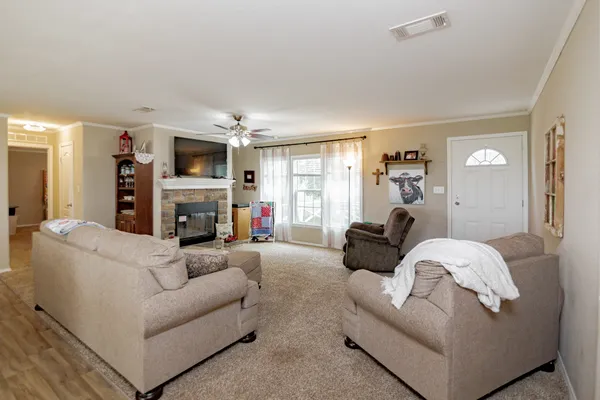 a living room with furniture a fireplace and a large window