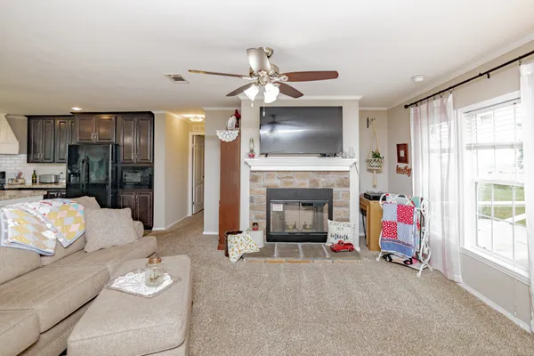 a living room with furniture a flat screen tv and a fireplace