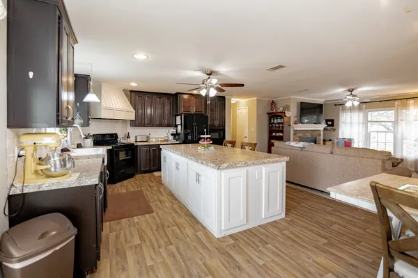 a large kitchen with stainless steel appliances kitchen island granite countertop a stove and a sink