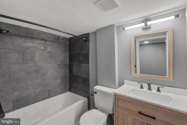 a bathroom with a sink toilet vanity and shower