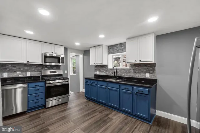 a large kitchen with stainless steel appliances and wooden cabinets