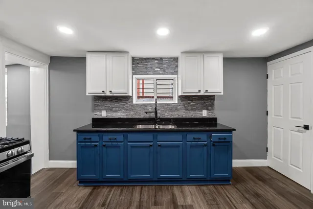 a kitchen with granite countertop wooden cabinets a sink and appliances