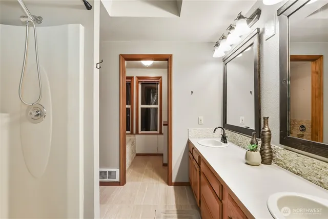 a en suite bathroom with a granite countertop sink and a mirror