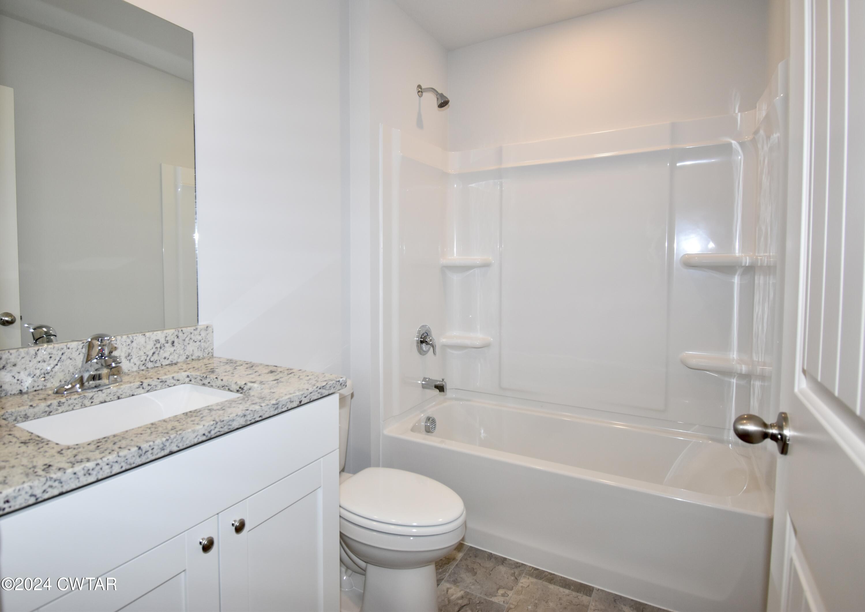 48 Vintage Grove Road Jackson, TN 38305 - Photo 15 of 19 a bathroom with a granite countertop sink a toilet and a bathtub