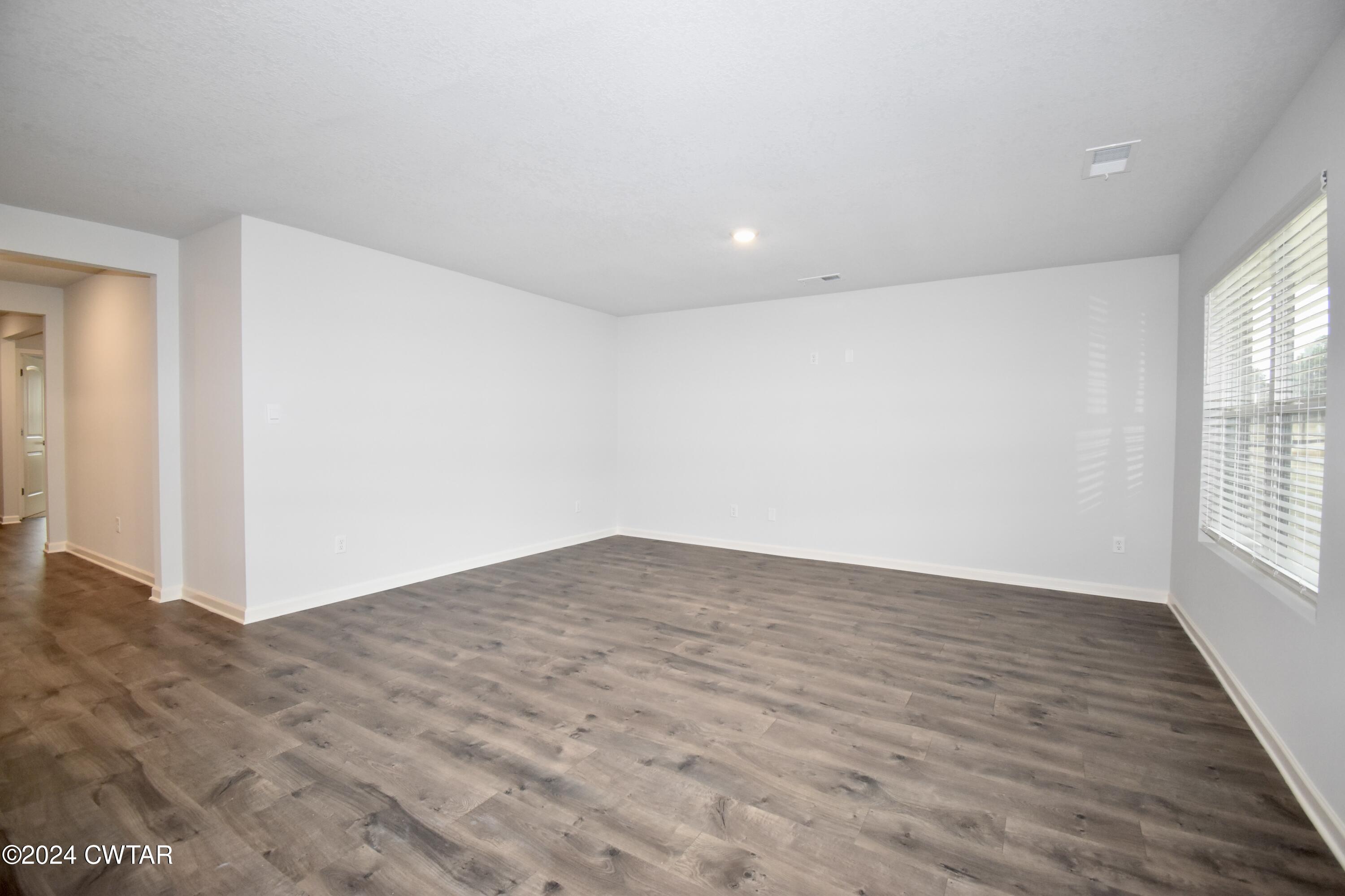 48 Vintage Grove Road Jackson, TN 38305 - Photo 2 of 19 an empty room with wooden floor and windows