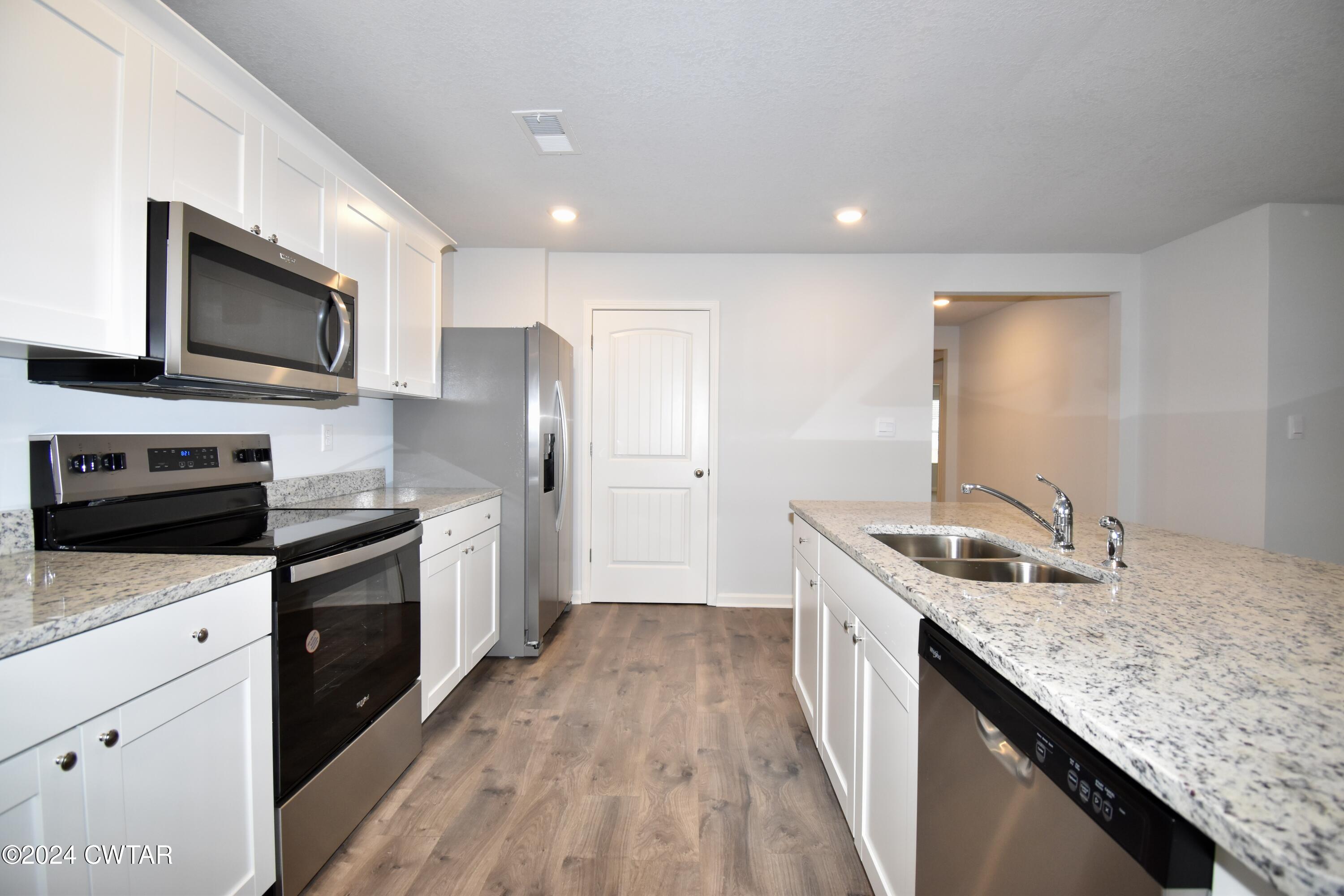 48 Vintage Grove Road Jackson, TN 38305 - Photo 6 of 19 a kitchen with stainless steel appliances granite countertop a sink stove microwave and refrigerator