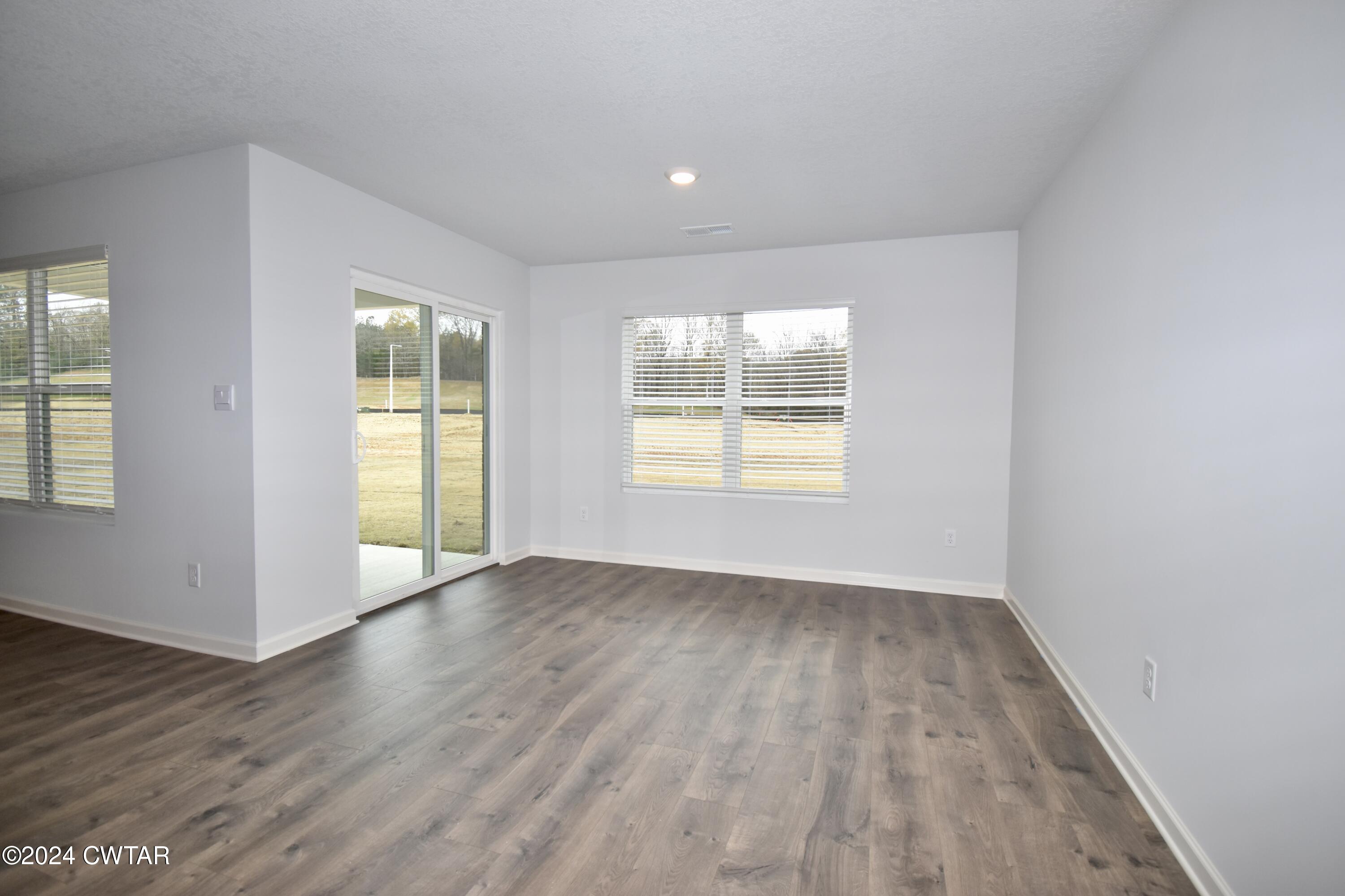 48 Vintage Grove Road Jackson, TN 38305 - Photo 8 of 19 an empty room with wooden floor and windows