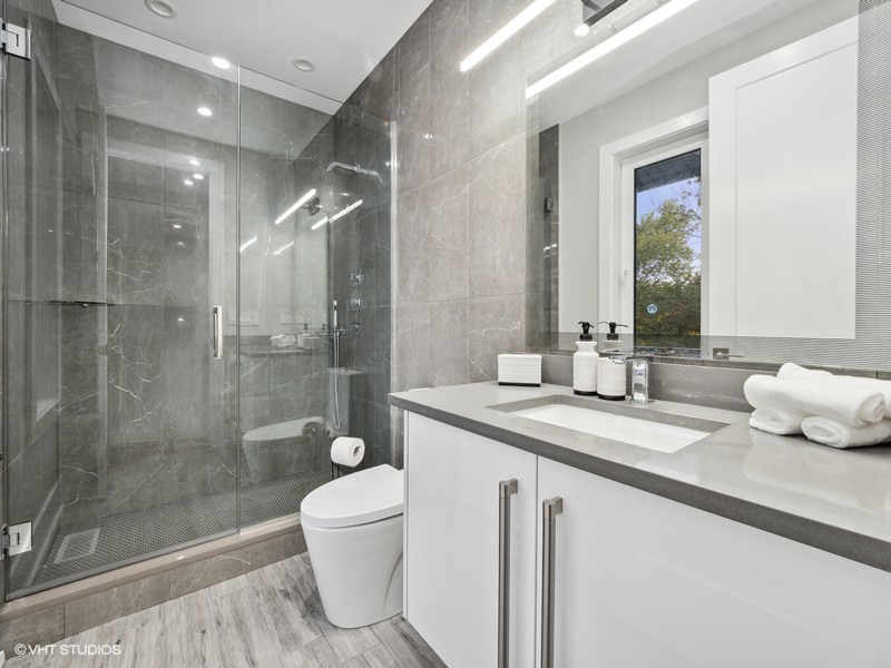 1341 Pfingsten Road Northbrook, IL 60062 - Photo 16 of 58 a bathroom with a granite countertop sink a toilet and shower
