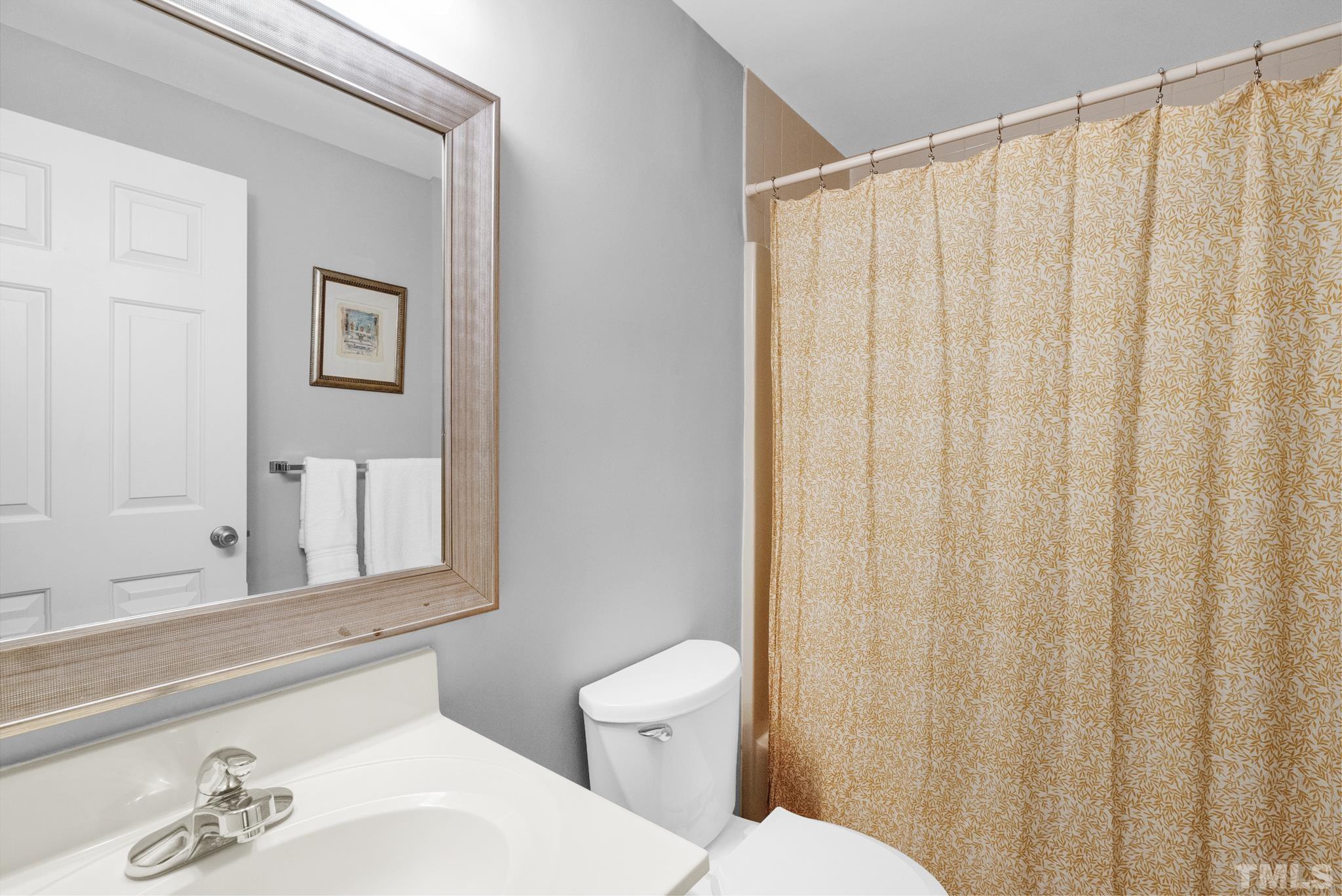 4650 Pine Trace Drive Raleigh, NC 27613 - Photo 20 of 26 a bathroom with a sink a toilet and shower curtain