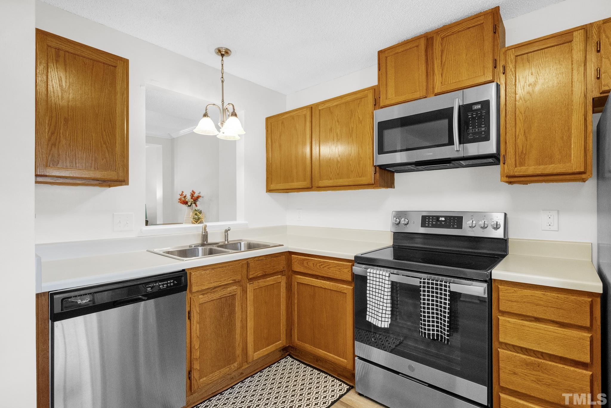 4650 Pine Trace Drive Raleigh, NC 27613 - Photo 5 of 26 a kitchen with stainless steel appliances granite countertop a sink stove and microwave