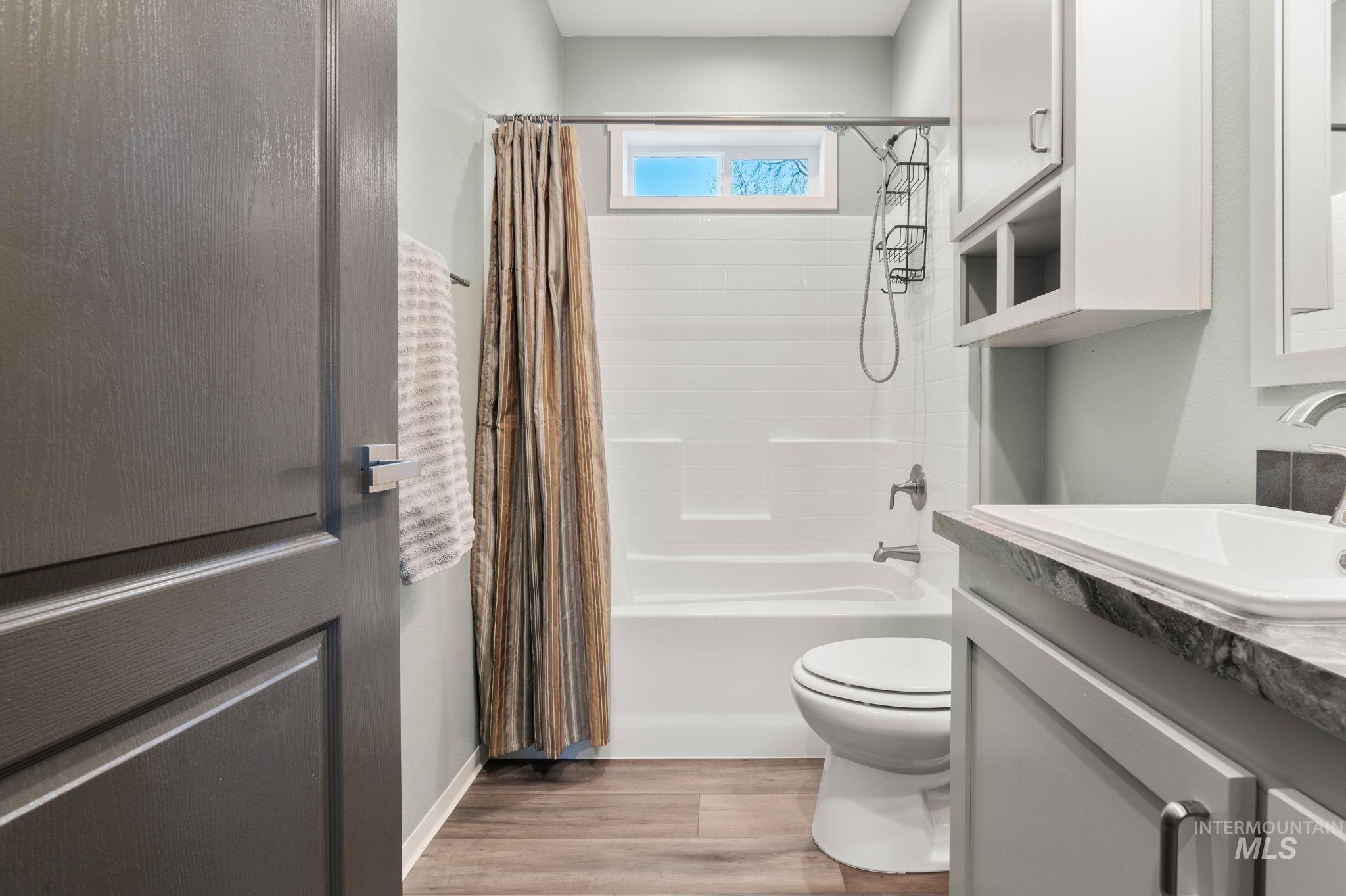 837 Burrell Avenue Lewiston, ID 83501 - Photo 17 of 32 Full bathroom featuring shower / bath combo with shower curtain, vanity, and wood finished floors