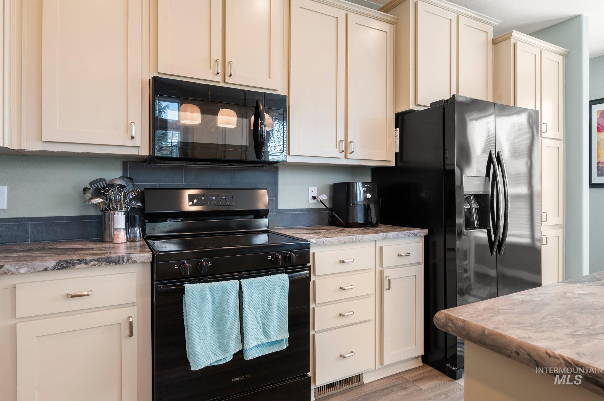 837 Burrell Avenue Lewiston, ID 83501 - Photo 24 of 32 Kitchen featuring black appliances, light wood-style flooring, and light stone counters
