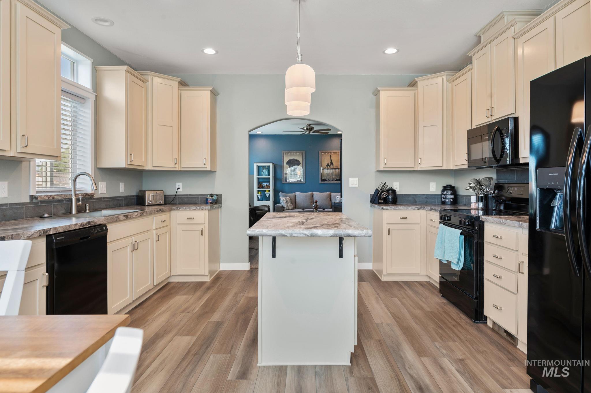 837 Burrell Avenue Lewiston, ID 83501 - Photo 25 of 32 Kitchen with black appliances, light wood-style flooring, cream cabinets, hanging light fixtures, and a ceiling fan