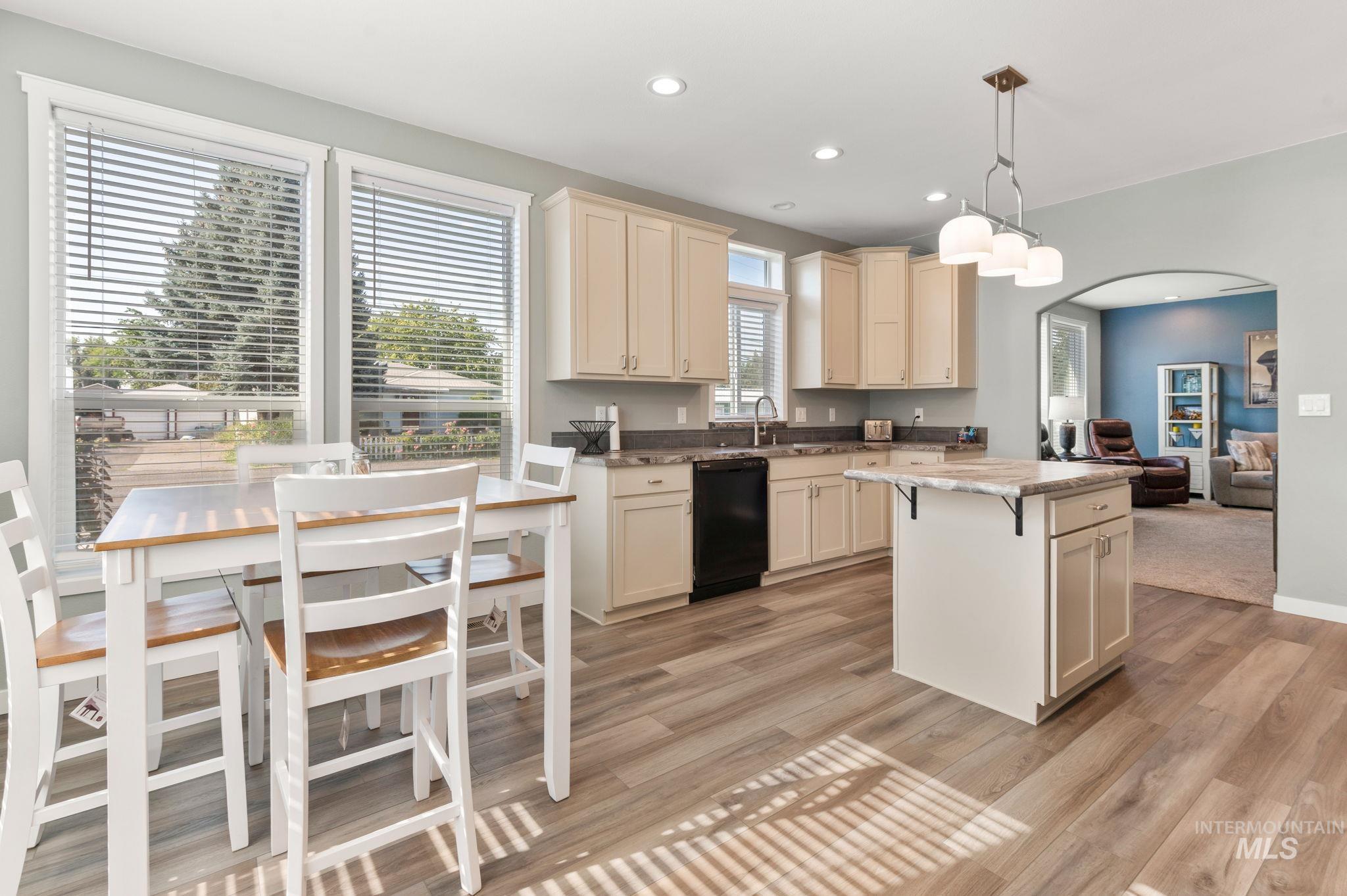 837 Burrell Avenue Lewiston, ID 83501 - Photo 27 of 32 Kitchen featuring dishwasher, light wood-style floors, a center island, arched walkways, and hanging light fixtures