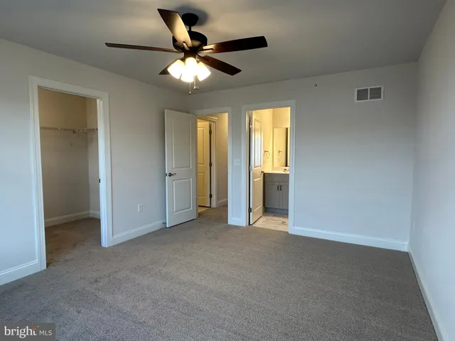 an empty room with fan and windows