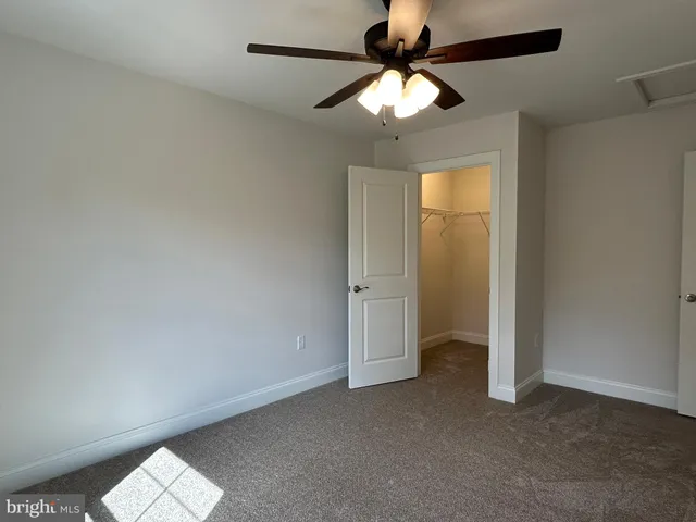 an empty room with a ceiling fan and a window