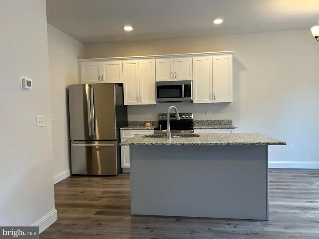 a kitchen with stainless steel appliances a refrigerator stove microwave and sink