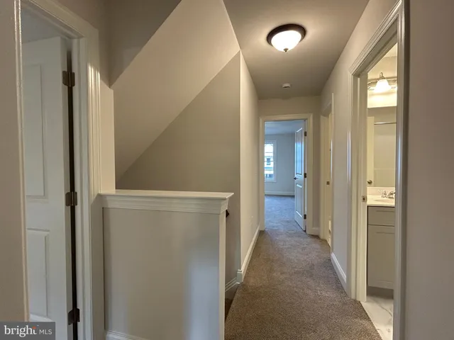 a view of a hallway with wooden floor and closet