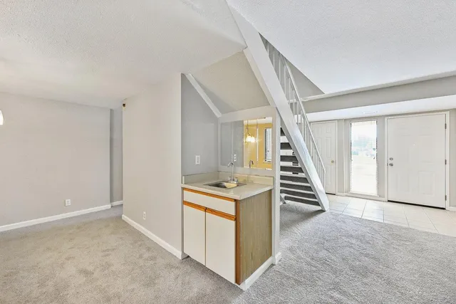 a view of a hallway with entryway and stairs