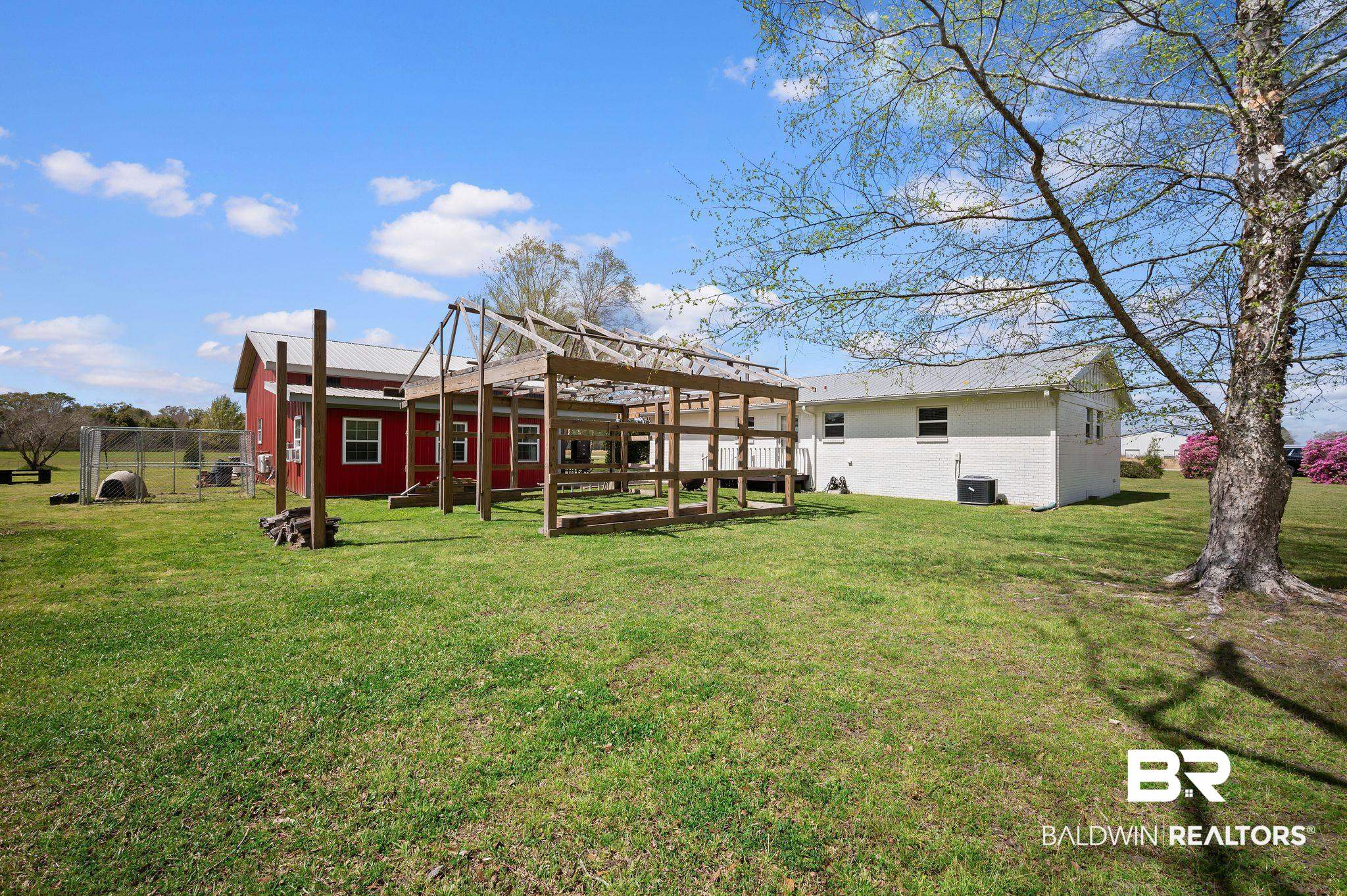 24924 Brewer Road Robertsdale, AL 36567 - Photo 25 of 33 Rear view of house featuring fence, central AC unit, and a yard