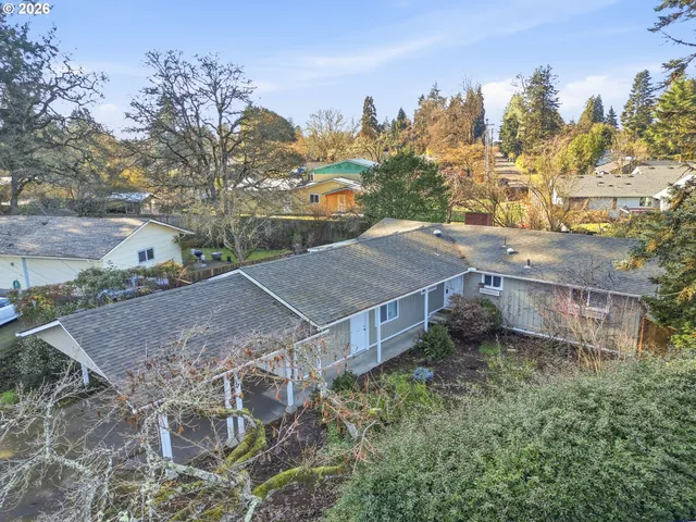 a view of a house with a yard and covered with trees