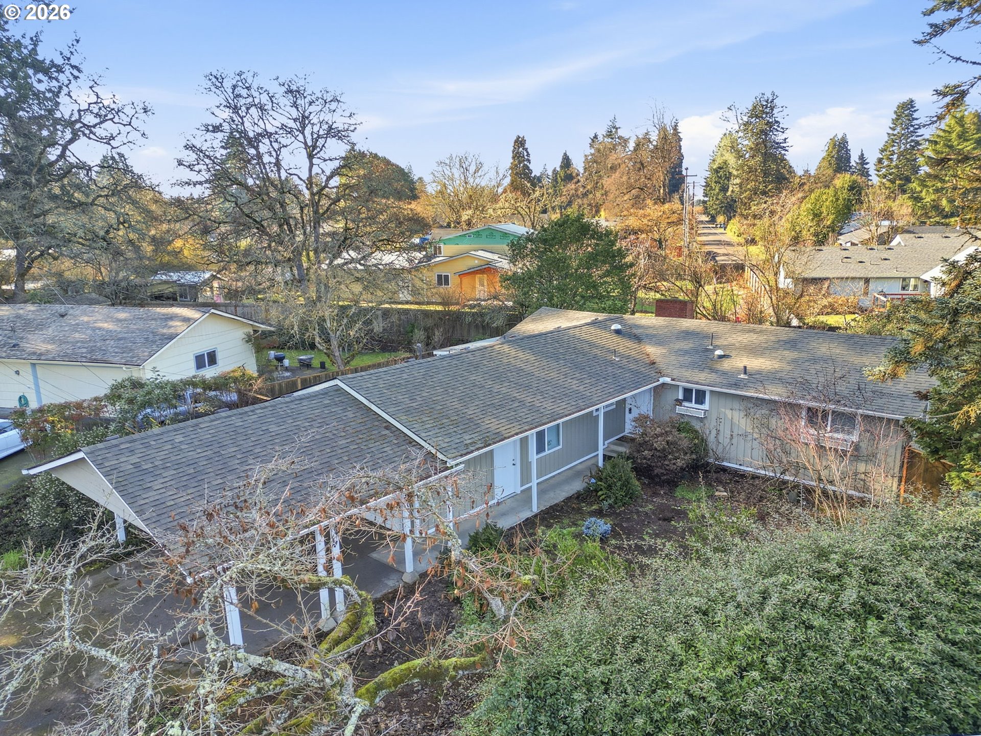 a view of a house with a yard and covered with trees