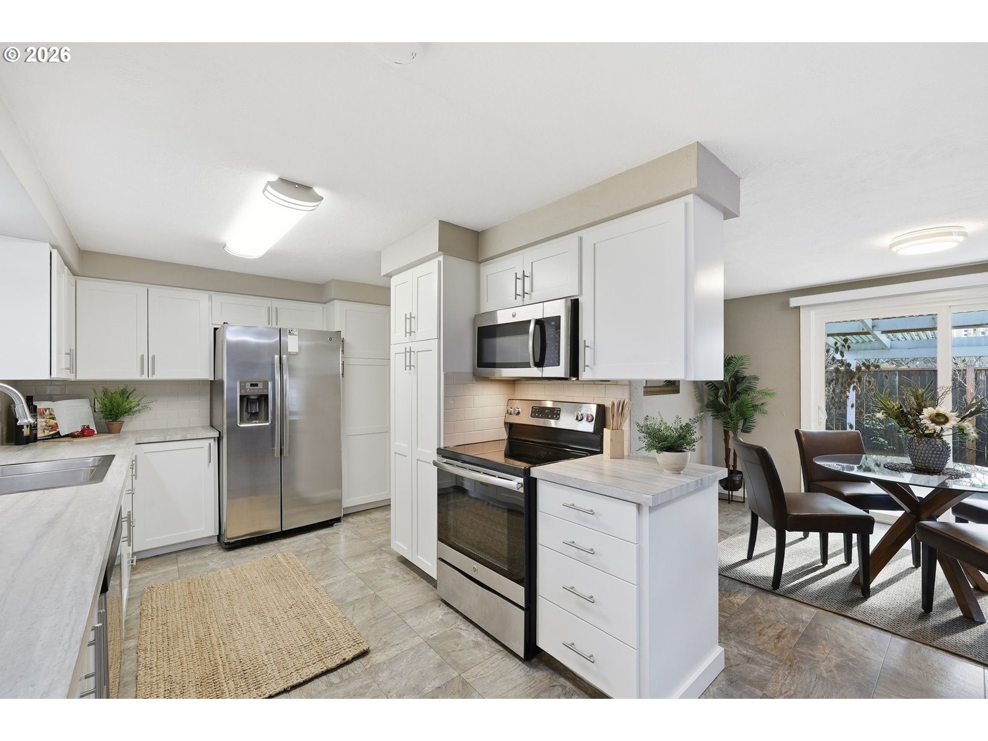 381 Marion Lane Eugene, OR 97404 - Photo 8 of 39 a kitchen with stainless steel appliances kitchen island granite countertop a refrigerator oven a stove a sink a dining table and chairs with wooden floor