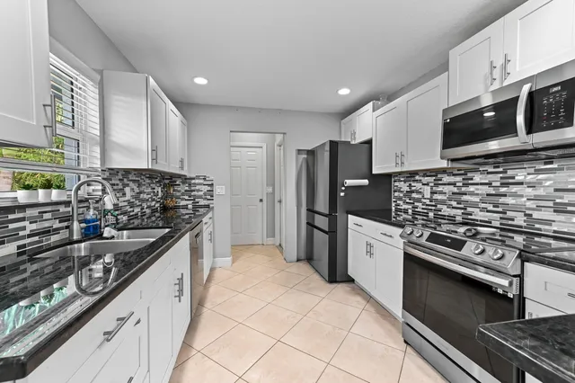 a kitchen with stainless steel appliances granite countertop a stove and a sink