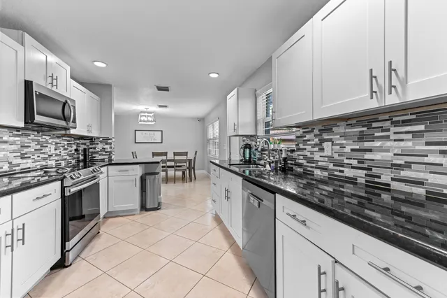 a kitchen with stainless steel appliances granite countertop a stove sink microwave and cabinets