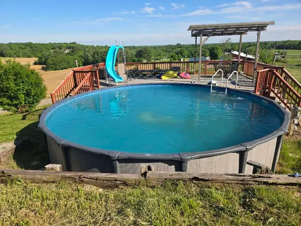 a view of a swimming pool with lawn chairs and plants