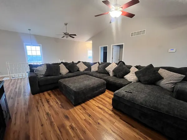 a living room with couches a fireplace and a chandelier