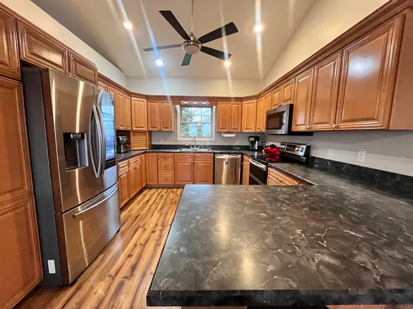 a kitchen with stainless steel appliances a refrigerator a sink a stove and cabinets