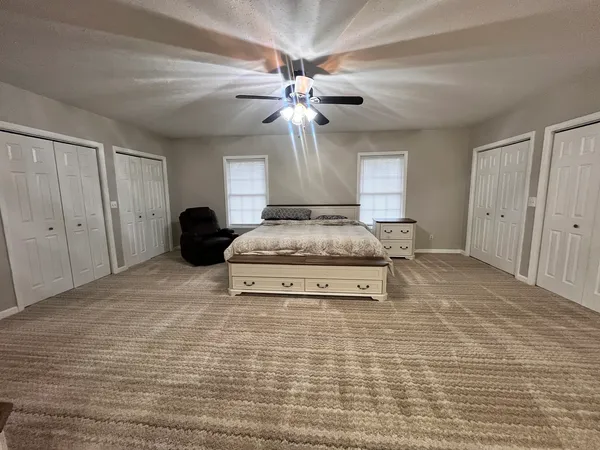 a bedroom with a bed and a ceiling fan