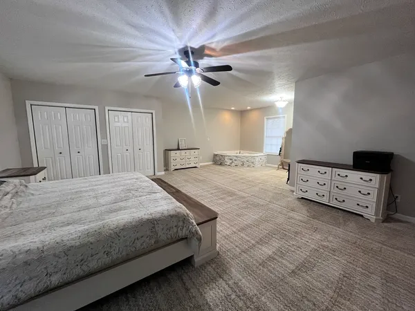 a spacious bedroom with a bed and a chandelier