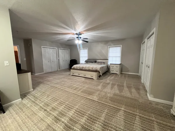 a spacious bedroom with a bed and a chandelier