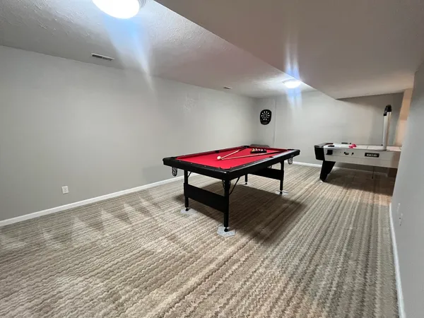 a room with pool table and wooden floor
