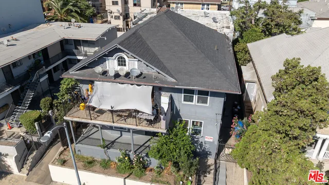 an aerial view of a house with table and chairs under an umbrella